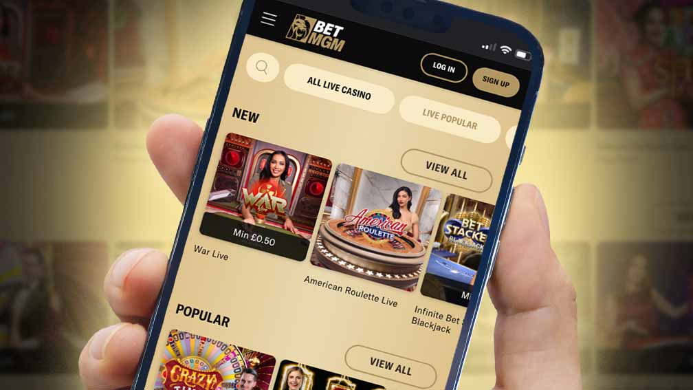 A hand holding a phone acessing the live casino page in the BetMGM app